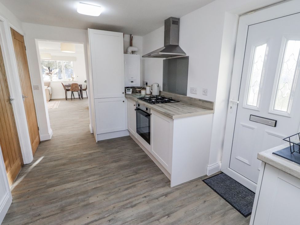 A kitchen with appliances and cabinets at Old Colliery Cottage in Shilbottle