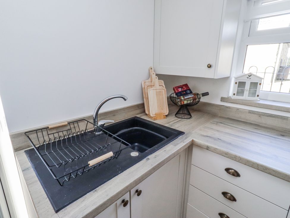 A kitchen with a sink and dish drainer at Old Colliery Cottage in Shilbottle