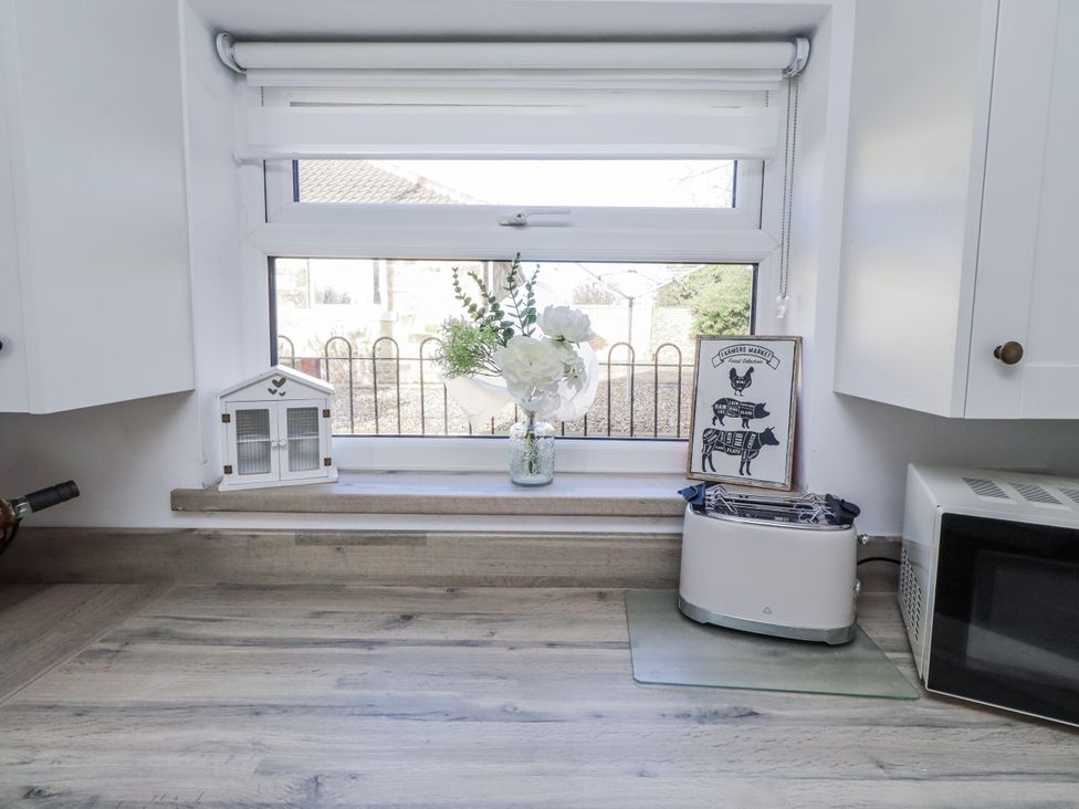 A kitchen countertop with a window and toaster at Old Colliery Cottage in Shilbottle