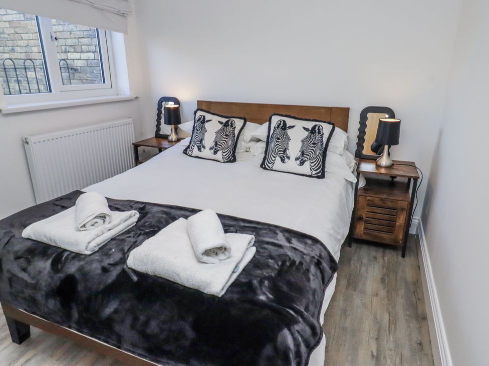 A bedroom with a bed and zebra print pillows at Old Colliery Cottage in Shilbottle