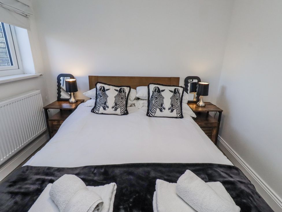 A bedroom with a bed and bedside tables at Old Colliery Cottage in Shilbottle