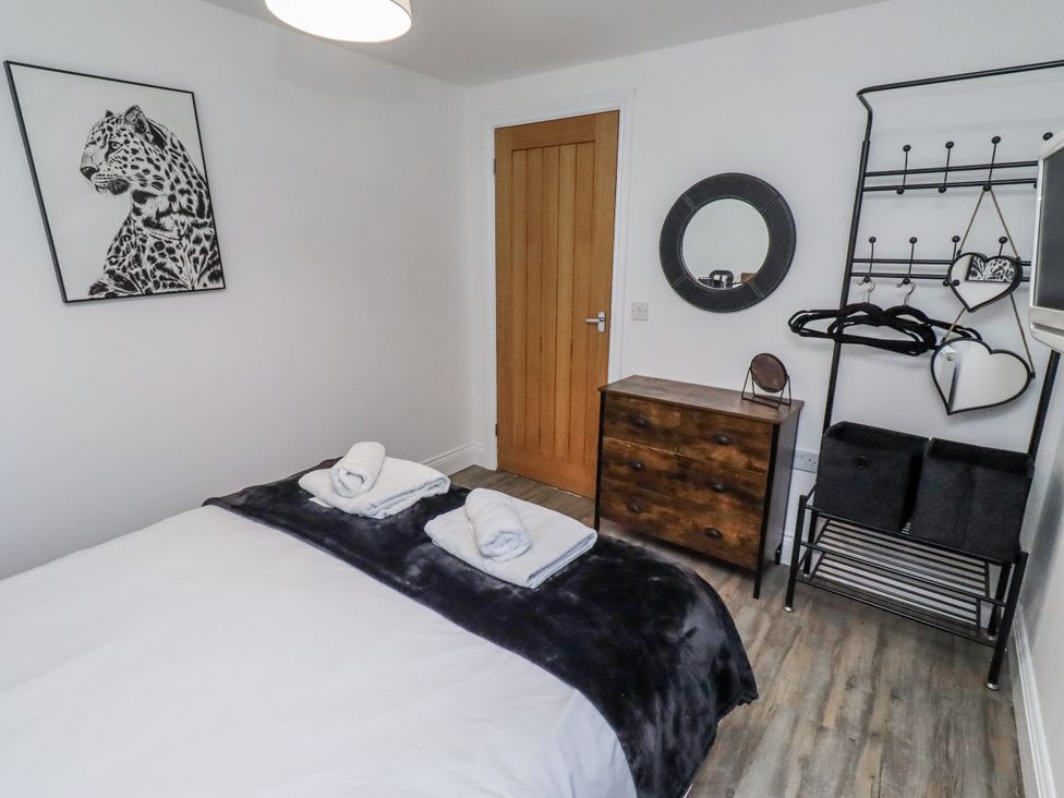 A bedroom with a bed and dresser at Old Colliery Cottage in Shilbottle