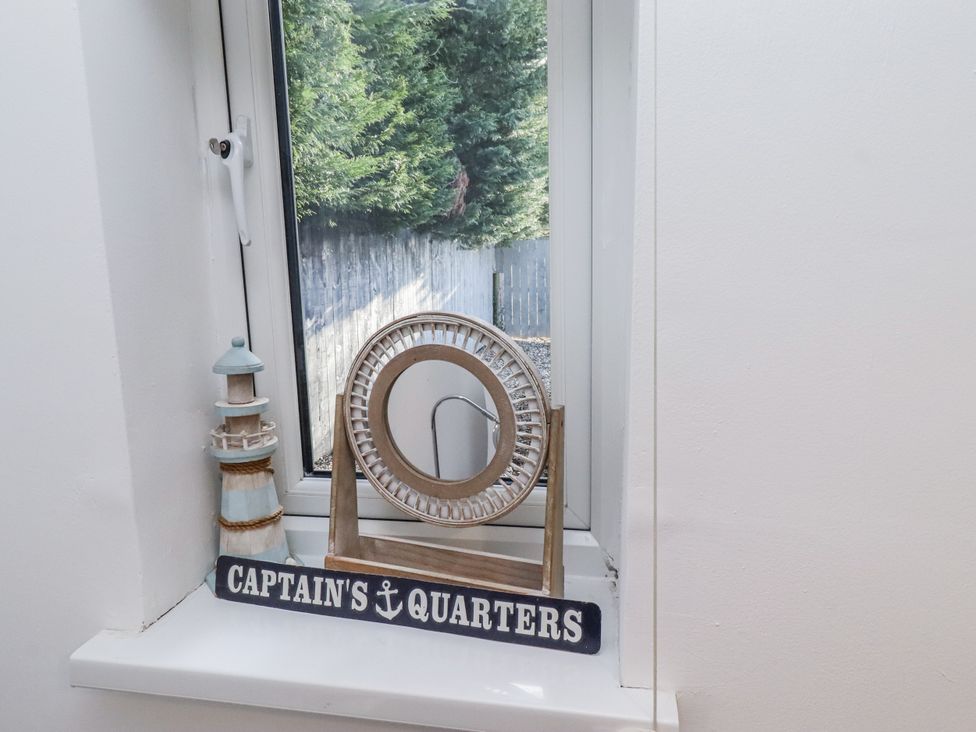 A decorative display with a lighthouse figurine and mirror at Old Colliery Cottage in Shilbottle