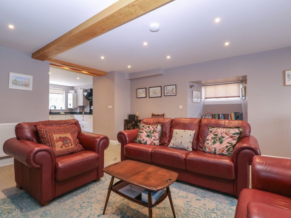 A living room with red sofas and a coffee table at 19 Lion Street in Hay-On-Wye