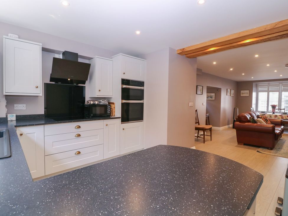 A kitchen with appliances and seating area at 19 Lion Street in Hay-On-Wye