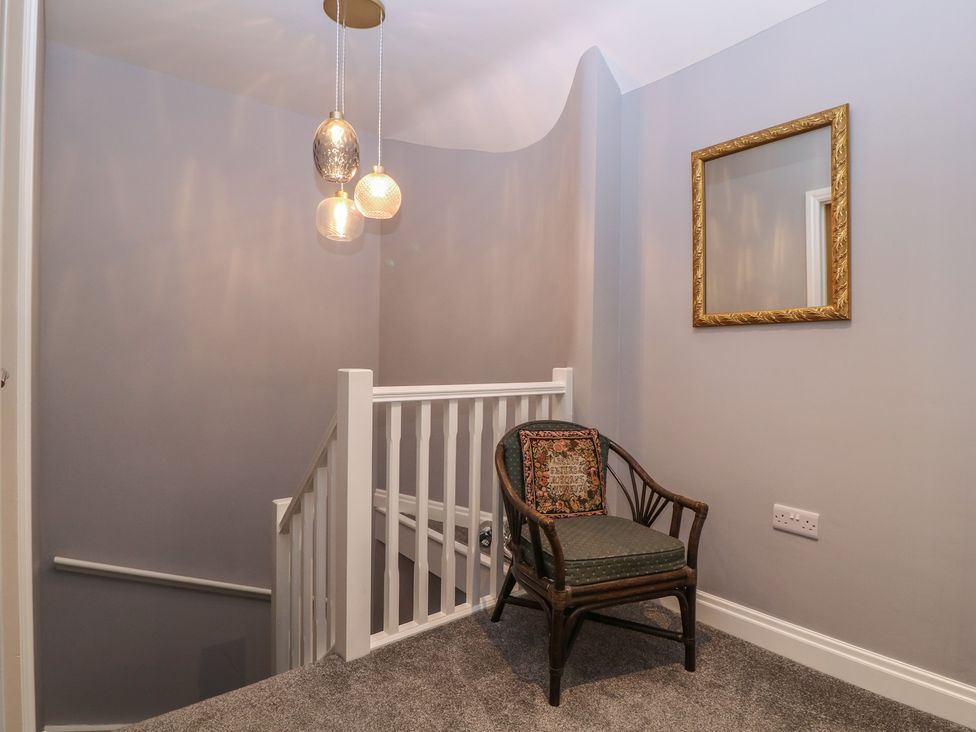 A landing with a chair and light fixture at 19 Lion Street Hay-On-Wye