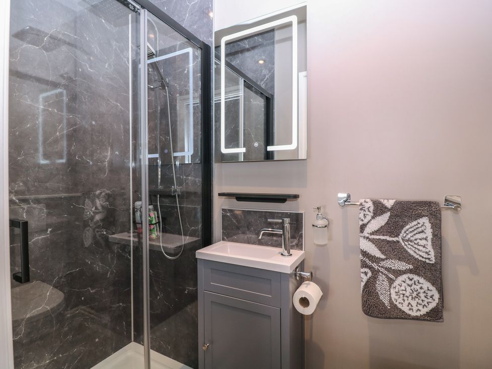 A bathroom with a shower, sink and mirror at 19 Lion Street in Hay-On-Wye