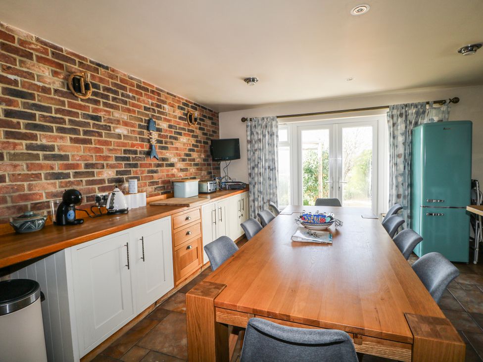 A kitchen with a dining table and chairs at 50 Harbour Road in Pagham