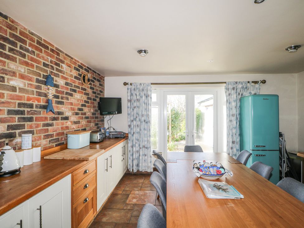 A kitchen with a dining table and chairs at 50 Harbour Road in Pagham