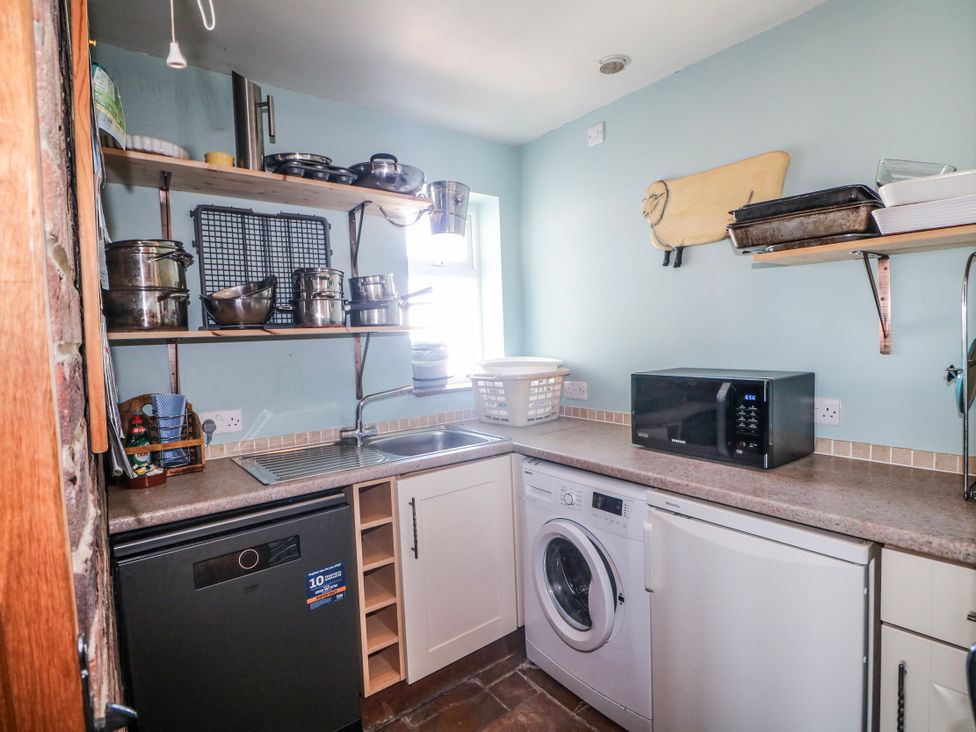 A kitchen with appliances and shelves at 50 Harbour Road in Pagham
