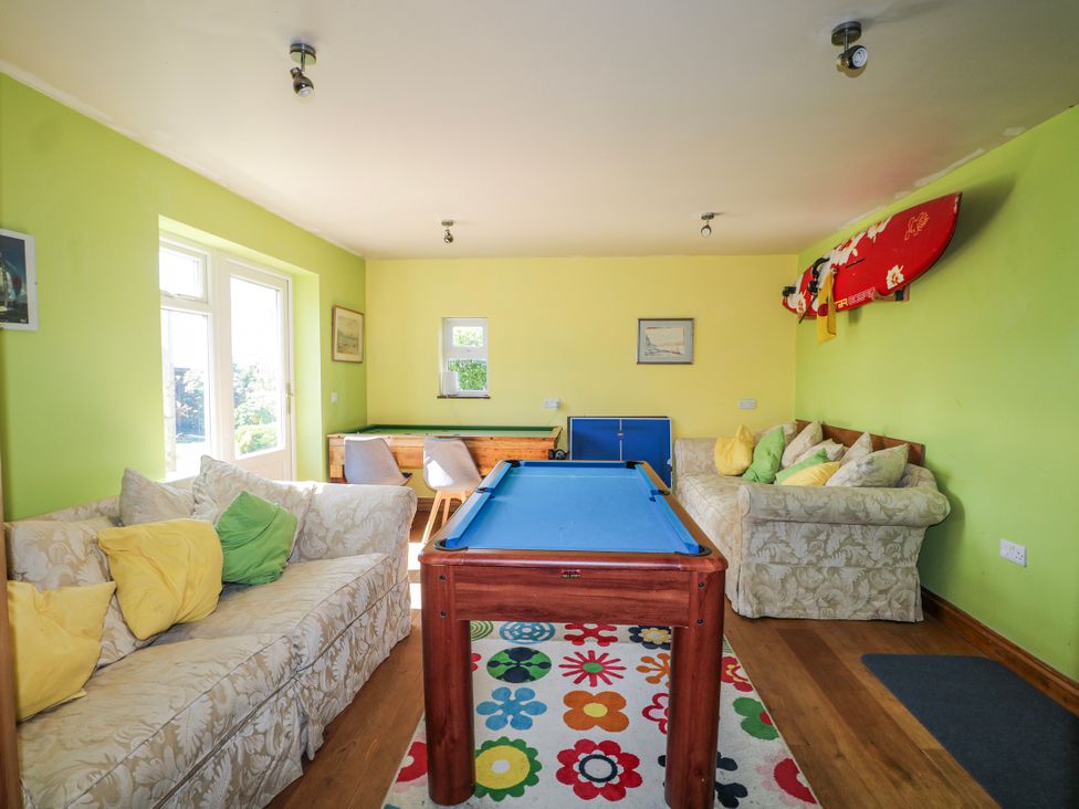 A snug with a pool table and sofas at 50 Harbour Road Pagham