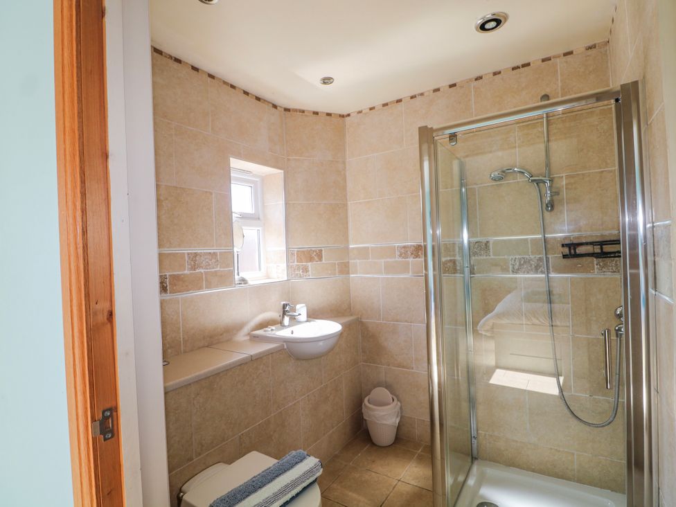A bathroom with a shower, toilet, and sink at 50 Harbour Road in Pagham