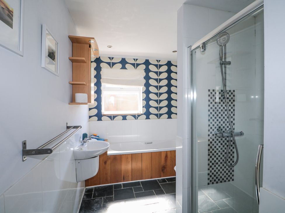 A bathroom with a bathtub, shower, and sink at 50 Harbour Road in Pagham