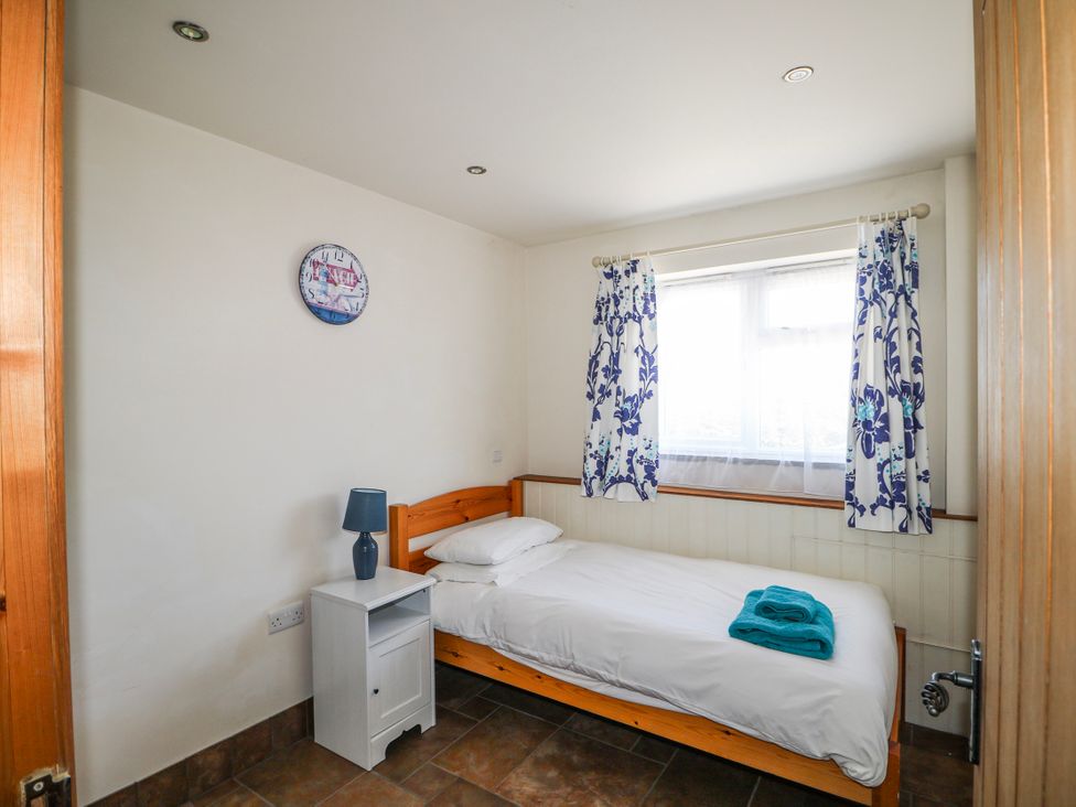 A bedroom with a single bed and bedside table at 50 Harbour Road Pagham