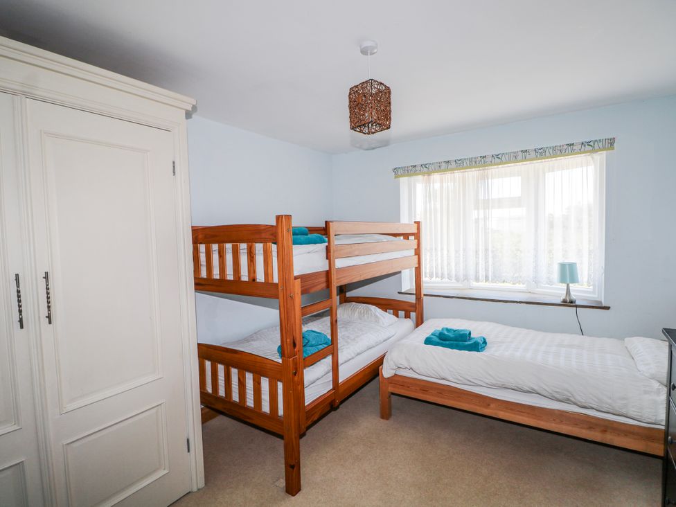 A bedroom with a bunk bed and a single bed at 50 Harbour Road, Pagham