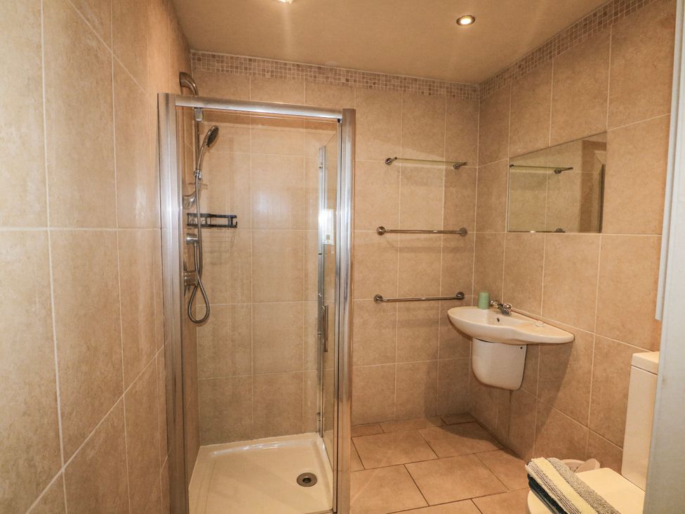 A bathroom with a shower, sink, and toilet at 50 Harbour Road Pagham