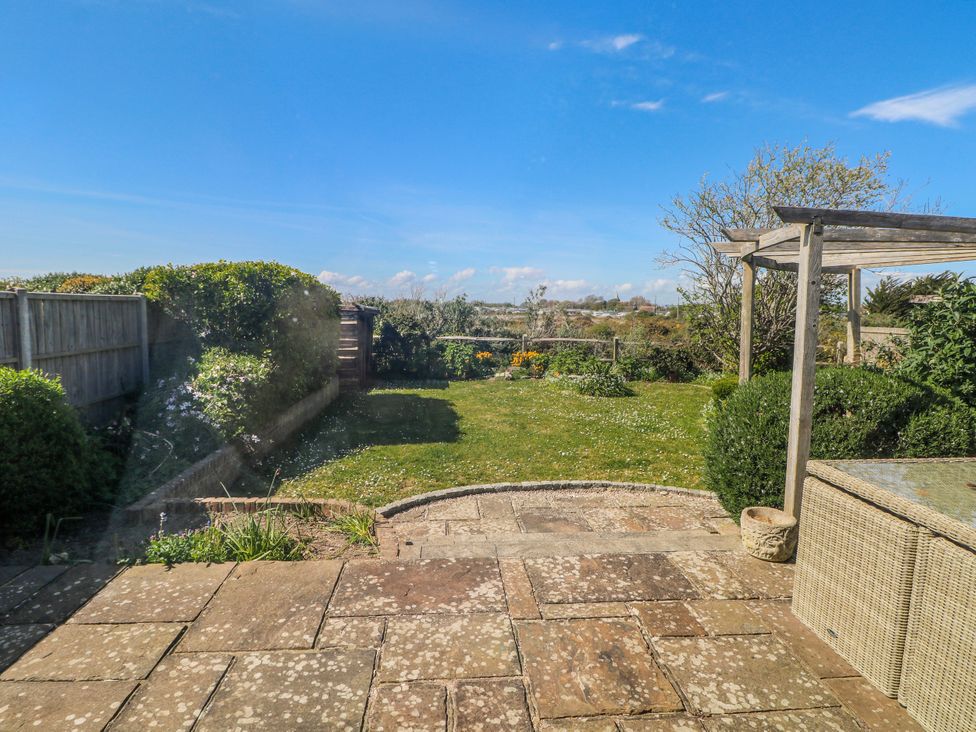 A garden with grass and shrubs at 50 Harbour Road in Pagham