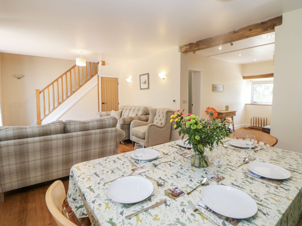 A dining room with a table set for dinner at The Coach House at Mayfurlong Farm in Grindon near Waterhouses
