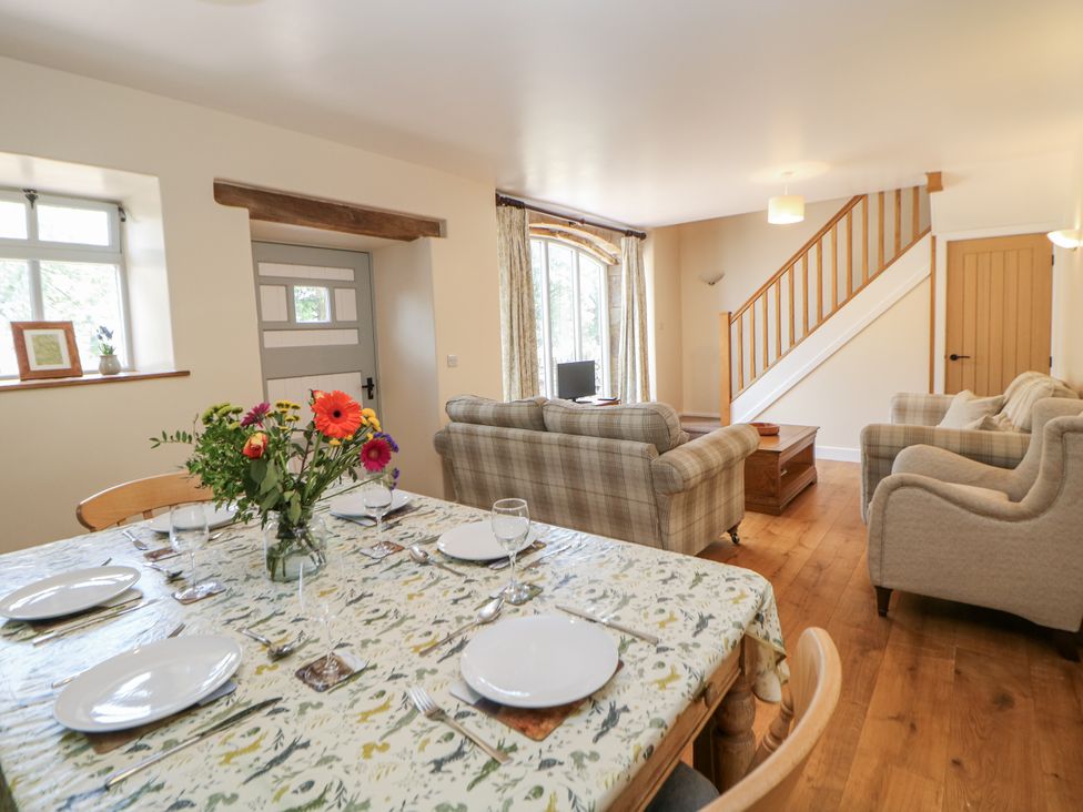 A dining room with a table set for dinner at The Coach House at Mayfurlong Farm Grindon near Waterhouses
