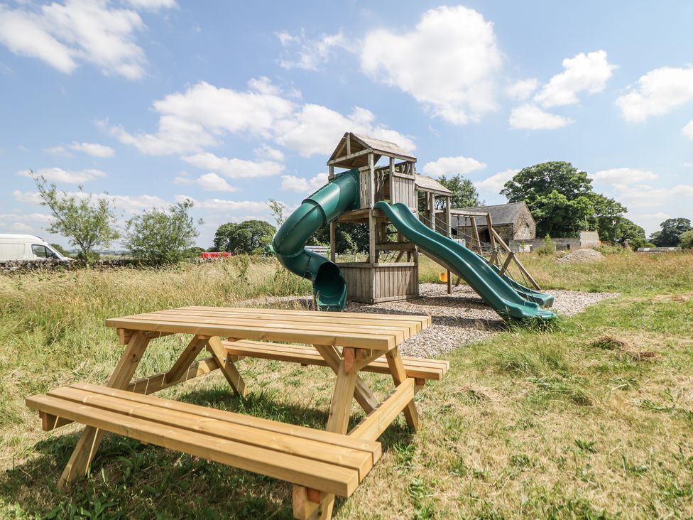 A playground with a slide and picnic table at The Coach House at Mayfurlong Farm Grindon near Waterhouses