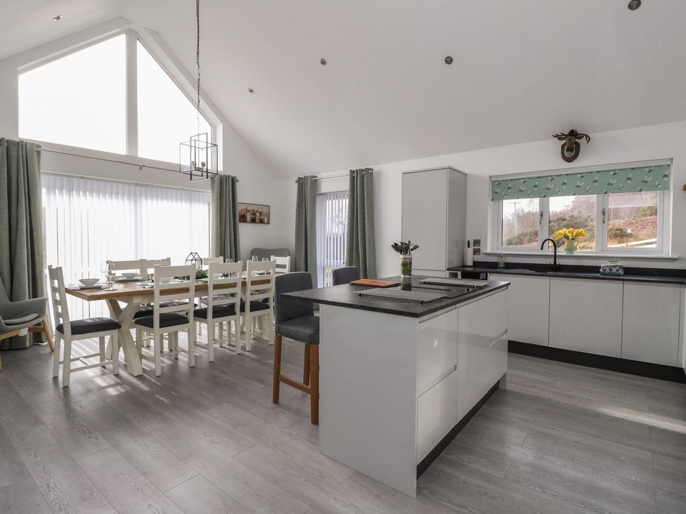 A kitchen with a dining table and chairs and a kitchen island at Eildan in Fort William