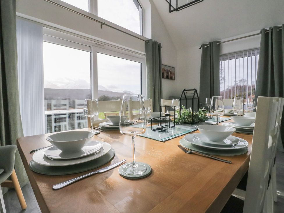 A dining room with a table set for a meal at Eildan in Fort William