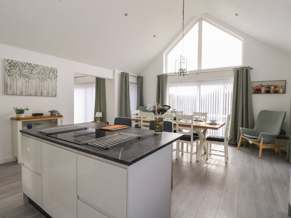 A kitchen with a dining table and large windows at Eildan in Fort William