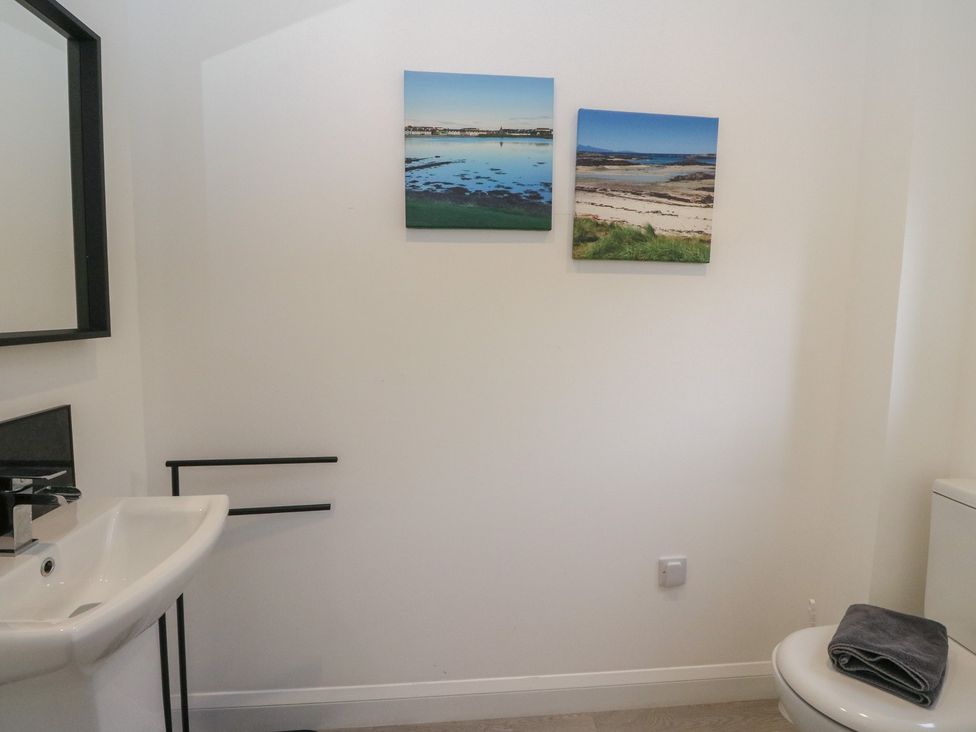 A bathroom with a sink, toilet, and wall art at Eildan in Fort William
