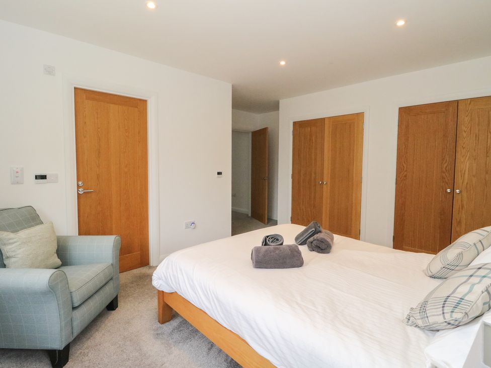 A bedroom with a bed and armchair at Eildan in Fort William