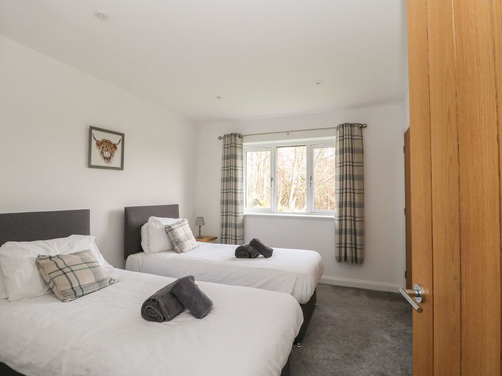 A bedroom with two beds and a window at Eildan in Fort William