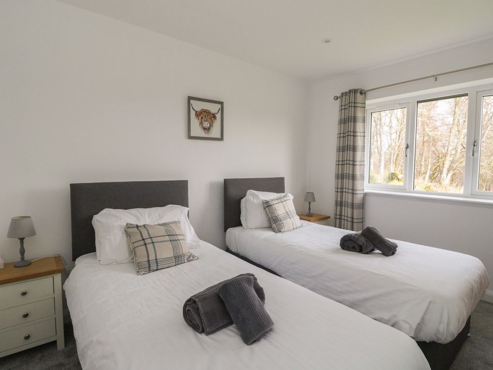 A bedroom with two single beds and a window at Eildan in Fort William
