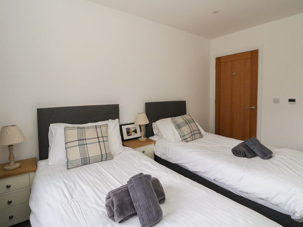 A bedroom with two beds and bedside lamps at Eildan in Fort William