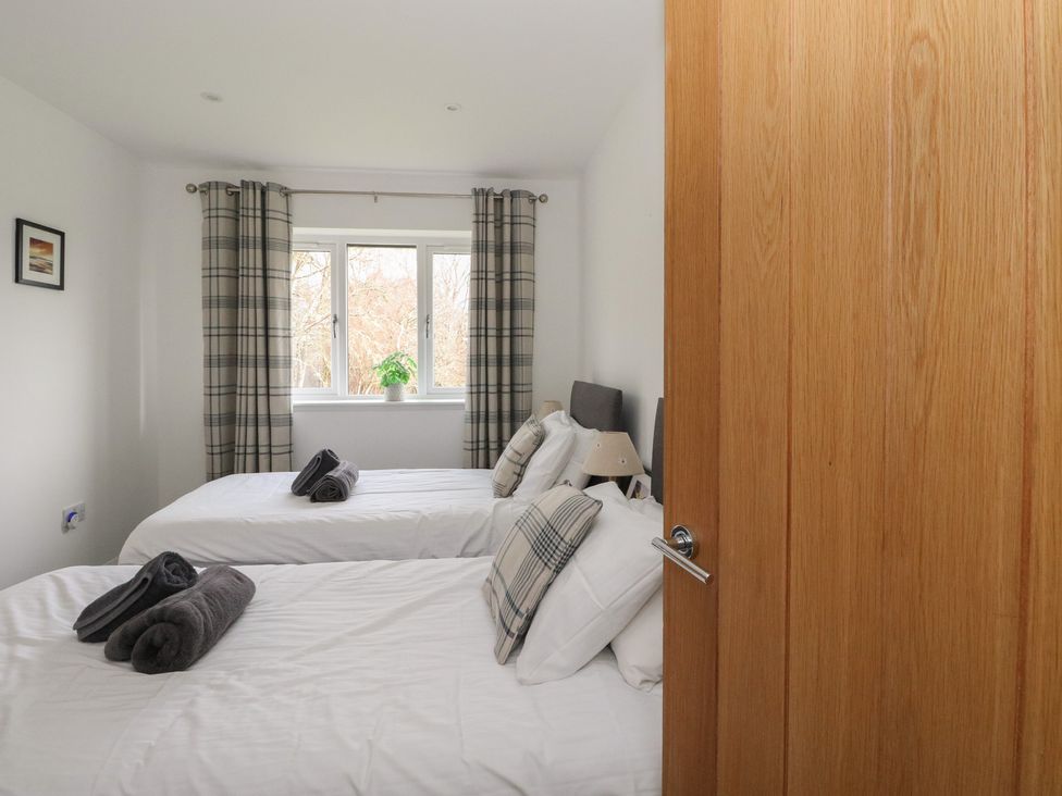 A bedroom with two beds and a window at Eildan in Fort William
