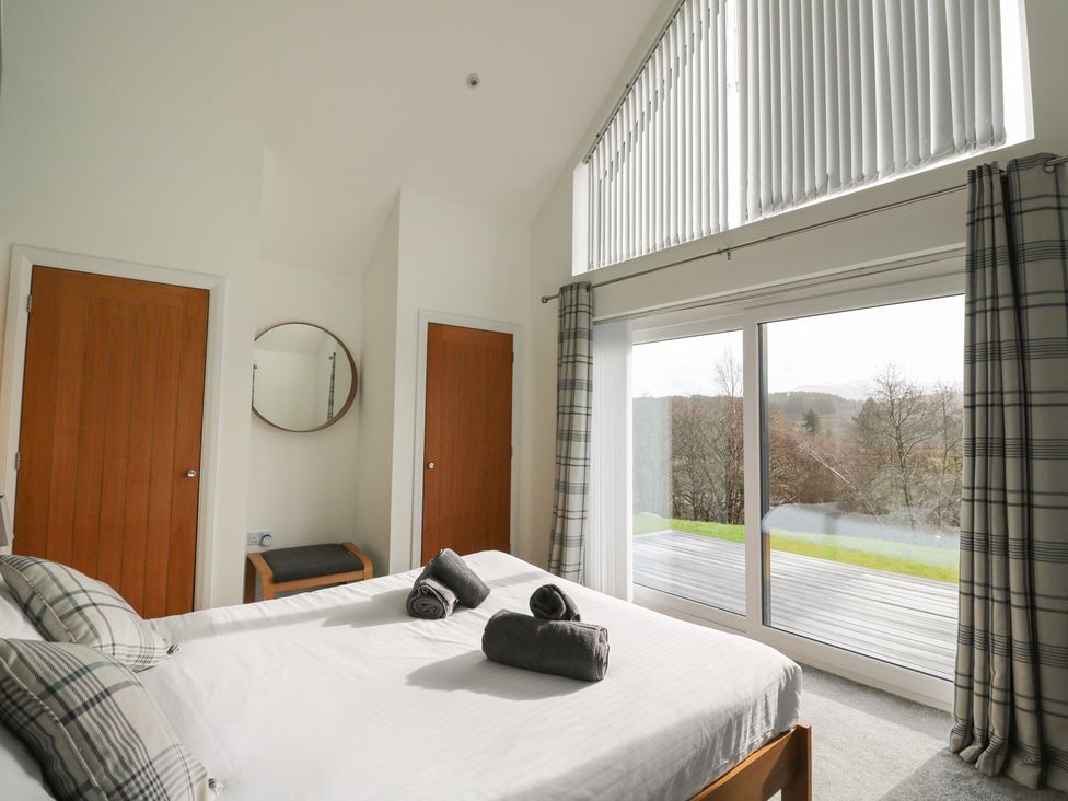 A bedroom with a bed and two doors at Eildan in Fort William