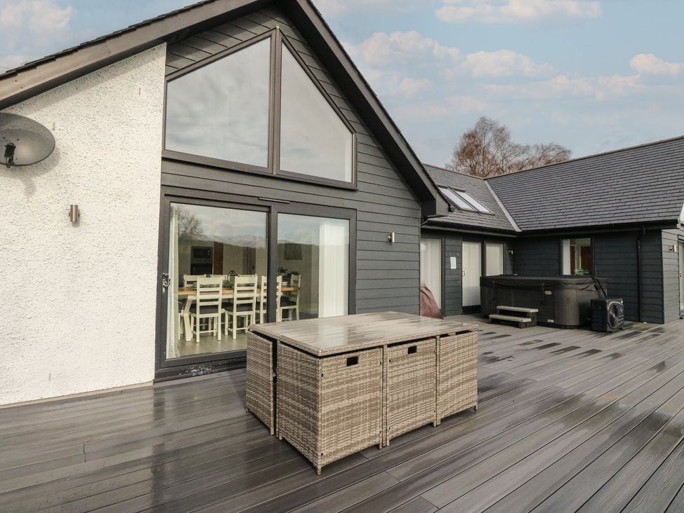 An outdoor area with a decking and dining table at Eildan in Fort William