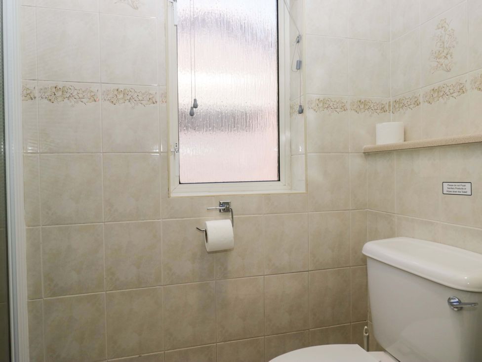 A bathroom with a toilet and window at Beech Timber Lodge in Keswick