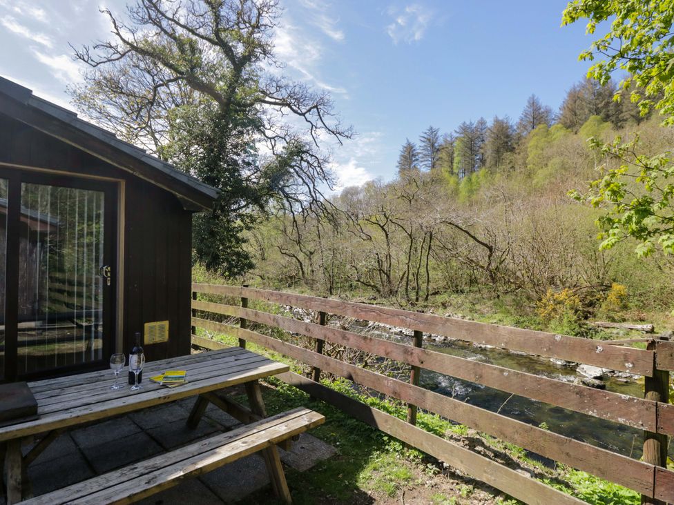 An outdoor seating area with a table and chairs at Beech Timber Lodge in Keswick