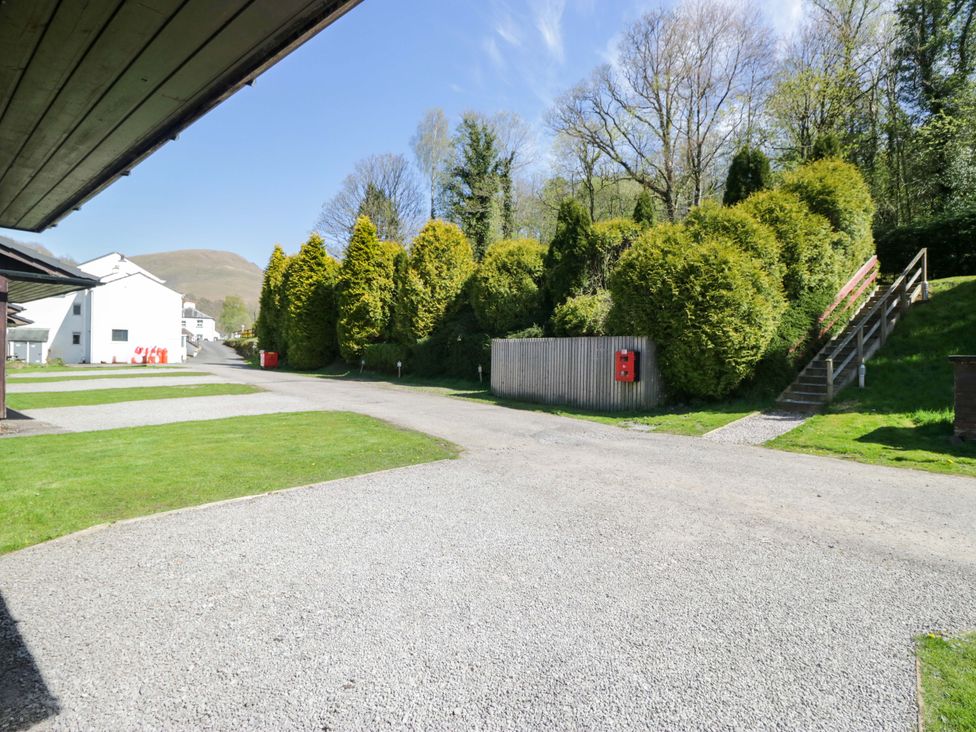 An outdoor area with gravel path and green grass at Beech Timber Lodge in Keswick