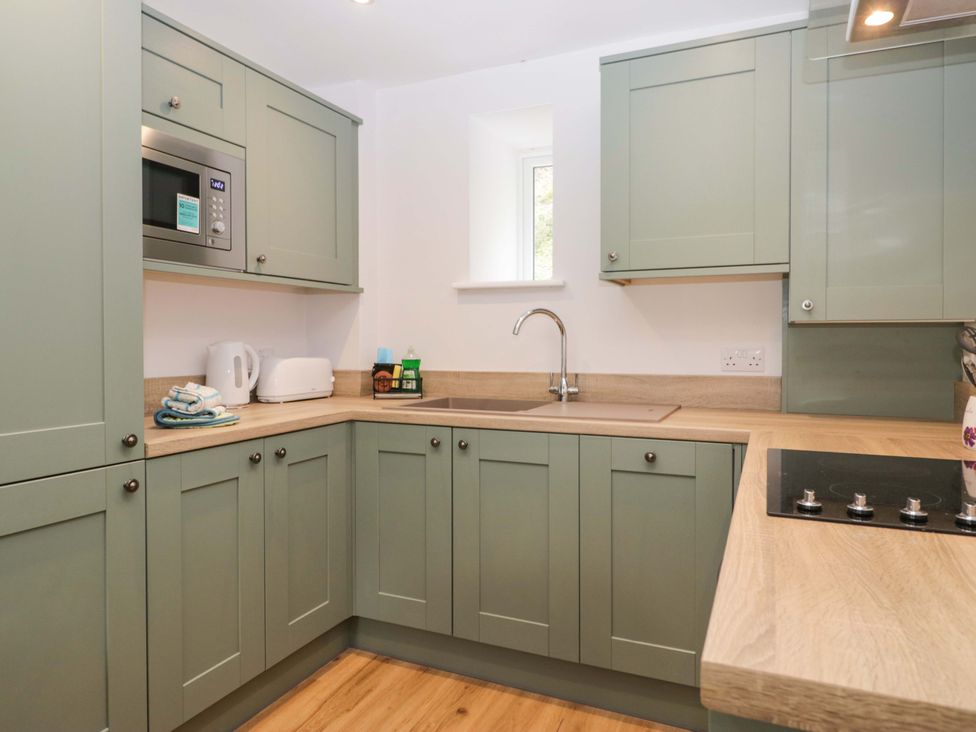A kitchen with cabinets and appliances at Riverside Cottage No 5 in Keswick