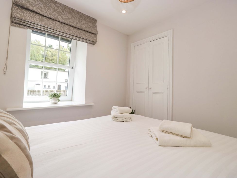 A bedroom with towels on the bed at Riverside Cottage No 5 in Keswick