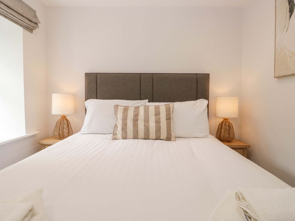 A bedroom with a bed and bedside lamps at Riverside Cottage No 5, Keswick