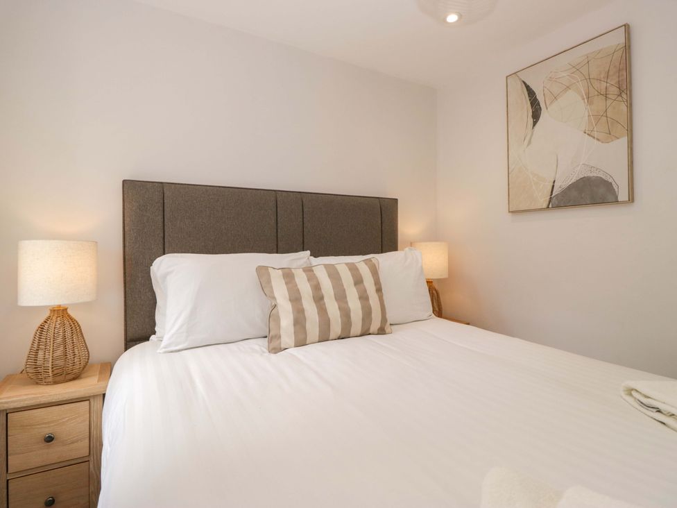 A bedroom with a bed and lamps at Riverside Cottage No 5 in Keswick
