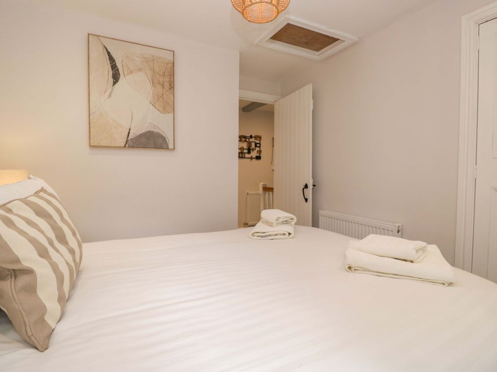 A bedroom with a bed and wall art at Riverside Cottage No 5 in Keswick