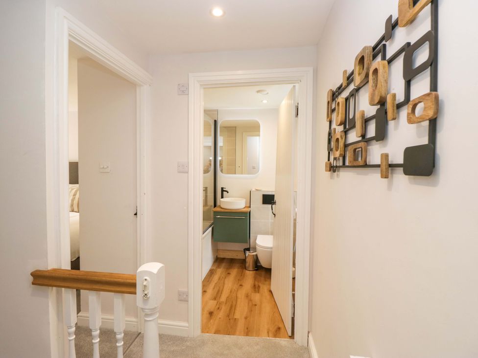 A hallway with a view of a bathroom and wall decor at Riverside Cottage No 5 in Keswick