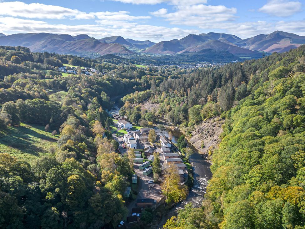 An aerial view of a village surrounded by mountains and trees at Riverside Cottage No 5 Keswick