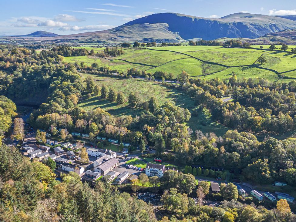An aerial view of a village with houses and green fields at Garden Cottage No 1 in Keswick