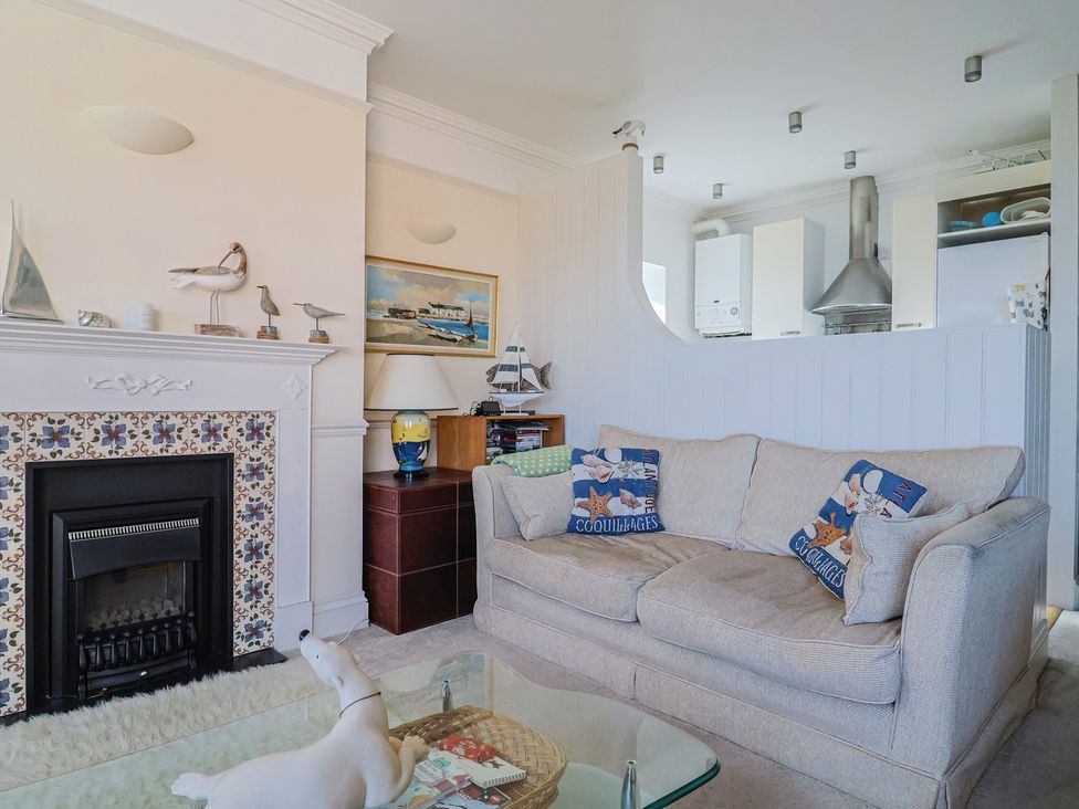 A living room with a sofa and fireplace at 2 St Michaels House in Lyme Regis