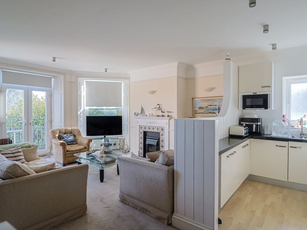 A living room with a sofa and armchair at 2 St Michaels House in Lyme Regis