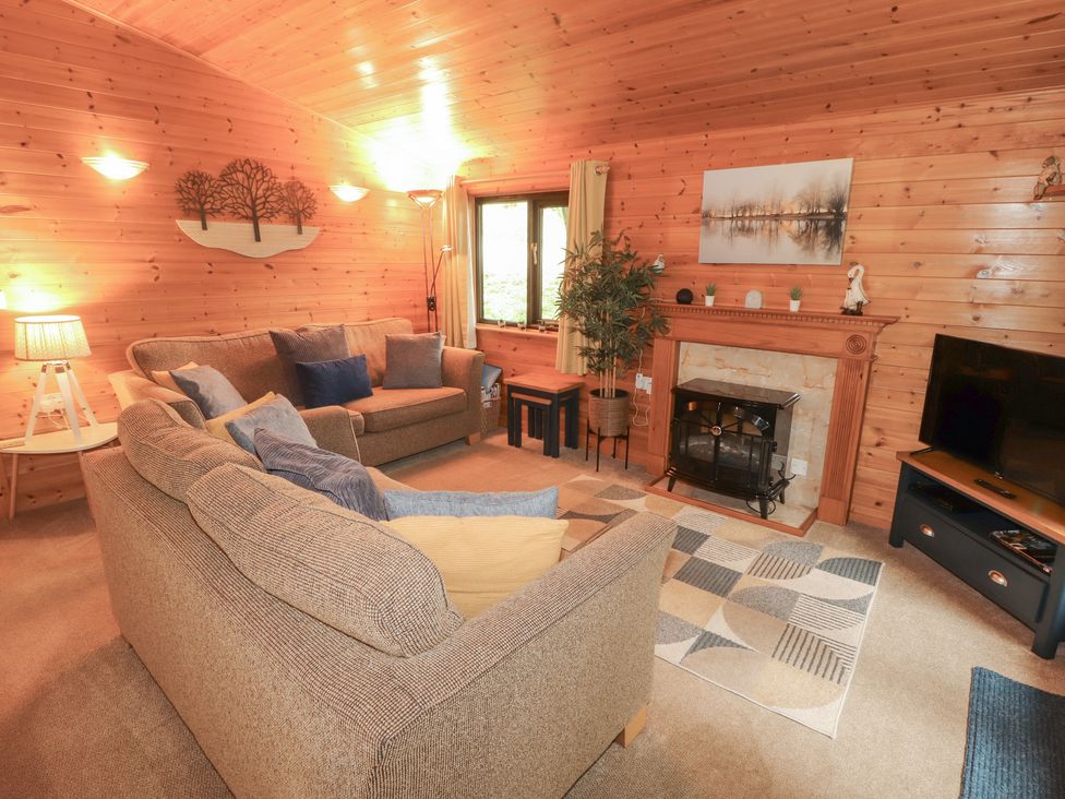 A living room with a sofa and fireplace at Derwent Lodge in Keswick
