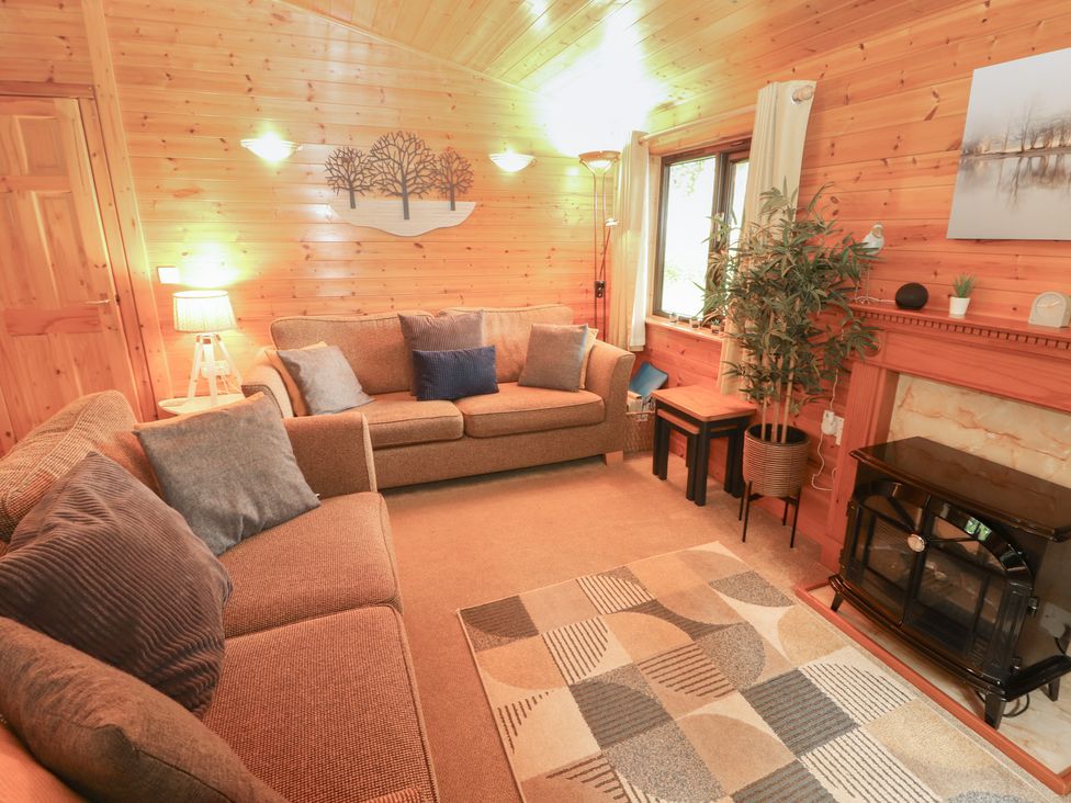 A living room with a sofa and fireplace at Derwent Lodge in Keswick